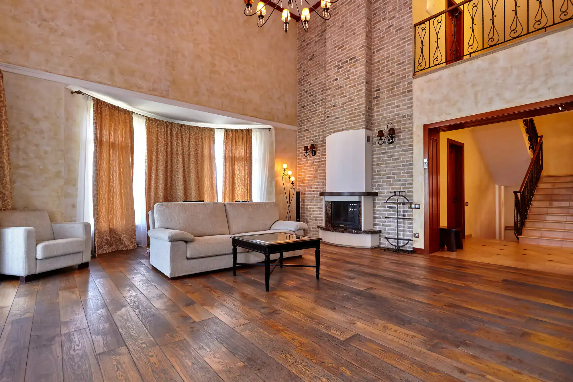 Spacious living room with hardwood floors, high ceilings, and cozy seating area.