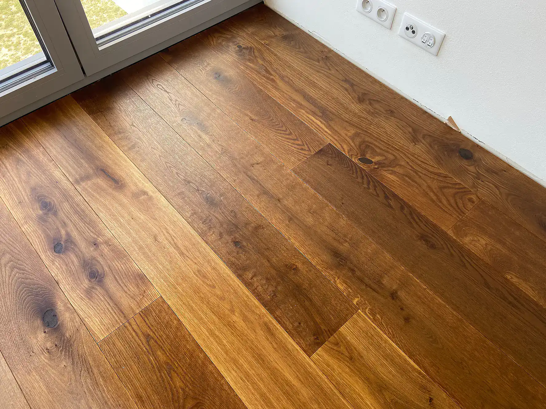 Beautiful hardwood flooring in a modern home near a sliding glass door.