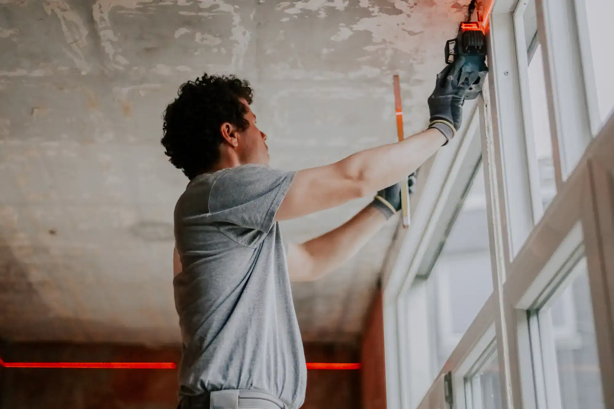 Worker installing window in a modern home for window replacement.