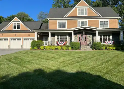 Beautiful modern house with well-maintained lawn and patriotic decorations.