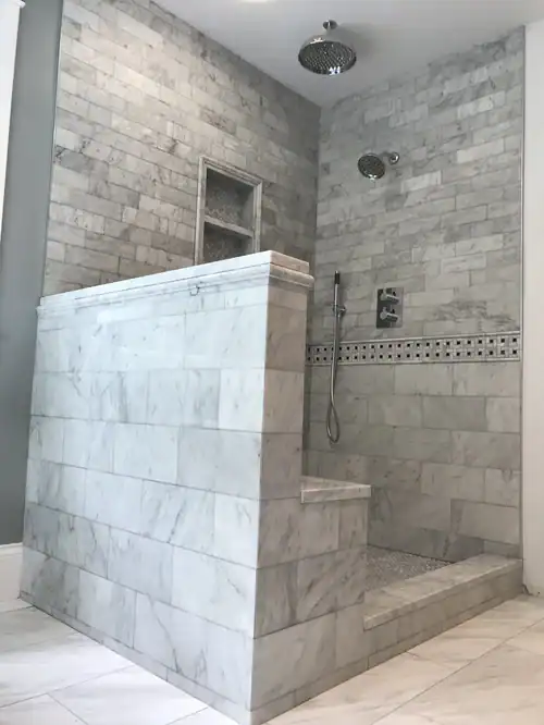 Modern marble shower with rain shower head and built-in bench.